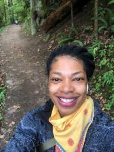 Smiling Black woman on a trail in the woods